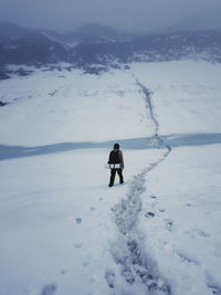 Man standing on snowcapped mountain during winter