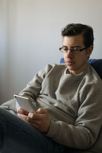 Portrait of young man sitting on sofa at home