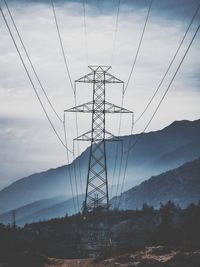 Low angle view of electricity pylon against sky