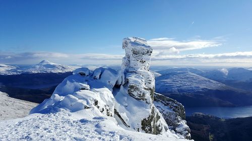 Scenic view of snowcapped mountains against blue sky