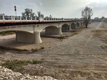 Arch bridge over river against sky