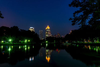 Reflection of illuminated buildings in calm lake at night