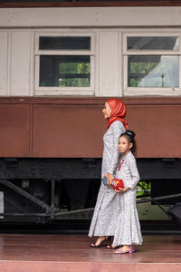 Side view of smiling girl holding umbrella