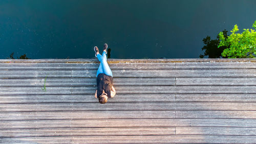 Rear view of woman on pier against blue sky