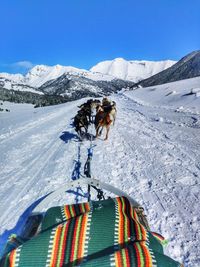 High angle view of people on snow covered mountain against sky