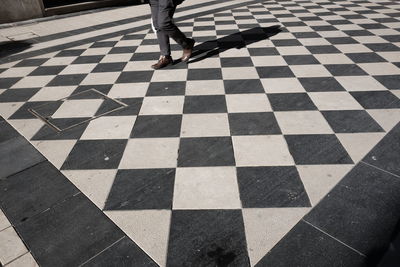 Low section of woman walking on tiled floor