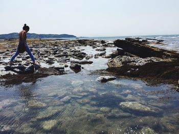 Rear view of woman standing on beach