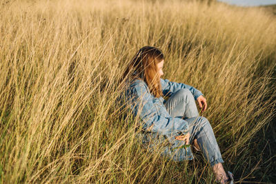 Side view of a man sitting on grass