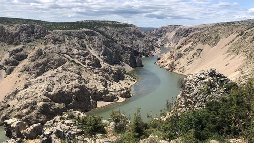 High angle view of lake amidst rock formations against sky