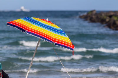 Sunshade sunbrella beach umbrella set against backdrop of the breaking waves
