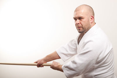 Man looking away while standing against white background