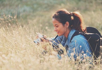 Smiling young woman photographing plants through camera