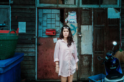 Portrait of woman standing against wall