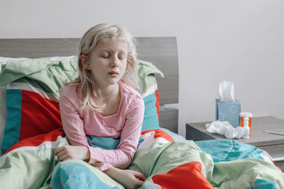 Girl sitting on bed at home