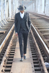 Full length of man walking on railroad track