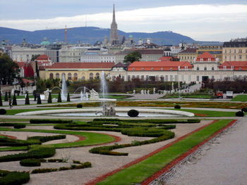 View of formal garden against buildings in city