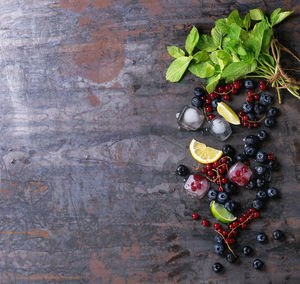 High angle view of fruits with herbs and ice cubes on table