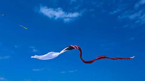 Low angle view of kite flying against blue sky