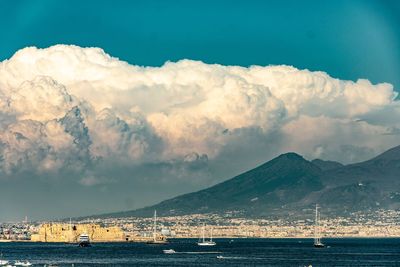 Scenic view of sea by mountains against sky