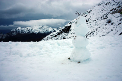 Cute snowman on top of a white snowy mountain with winter landscape