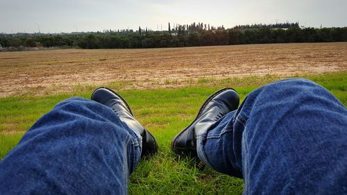 Low section of man relaxing on field