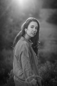 Portrait of smiling young woman standing on field