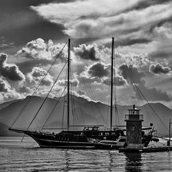 Sailboats moored on sea against sky