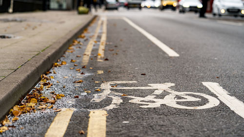 Worn bicycle lane sign painted on road