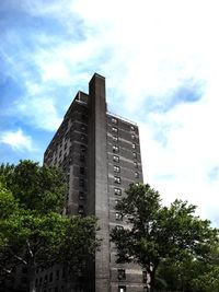 Low angle view of modern building against cloudy sky