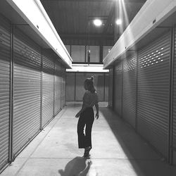 Full length rear view of woman walking in corridor of building