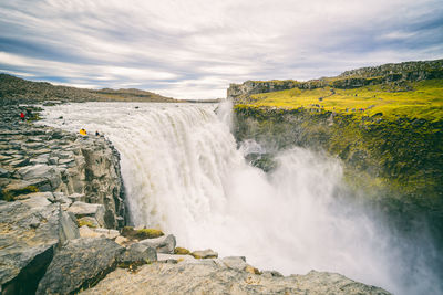 Scenic view of waterfall against sky