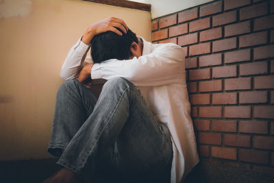 Midsection of woman sitting against wall