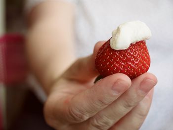 Close-up of hand holding strawberry