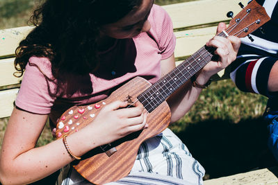 Midsection of woman playing guitar