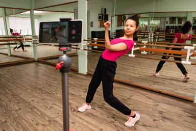 Full length of girl holding umbrella on floor