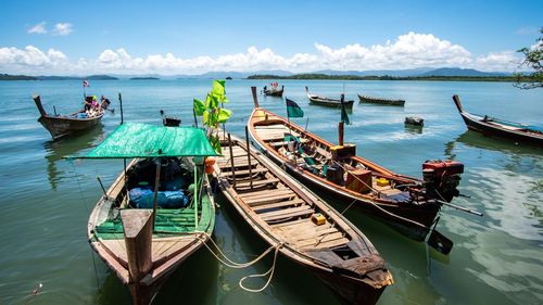 Panoramic view of boats moored in sea against sky