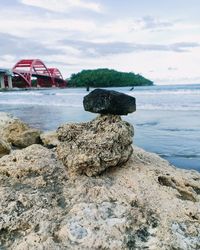 Scenic view of rocks on beach against sky