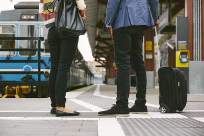 Low section of commuters standing at railroad station