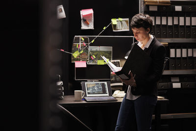 Portrait of businessman using digital tablet while standing in cafe