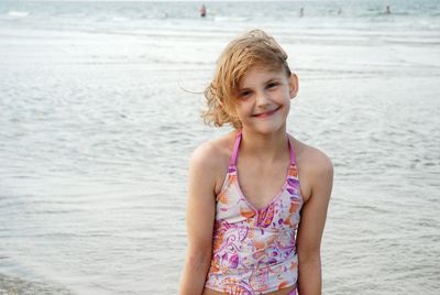 Portrait of cute smiling girl standing at beach