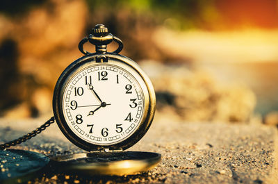 Close-up of pocket watch on concrete wall