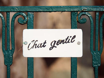 Close-up of sign on metallic railing