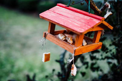 Close-up of wooden birdhouse hanging on tree