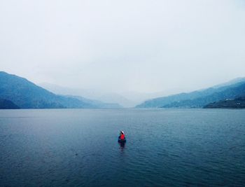 Rear view of people in canoe on lake