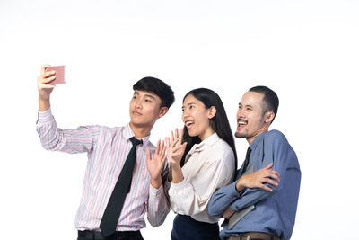 Young couple standing against white background