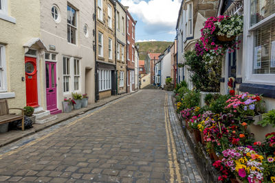 Street amidst houses and buildings against sky