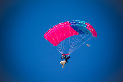 Low angle view of parachute against clear blue sky