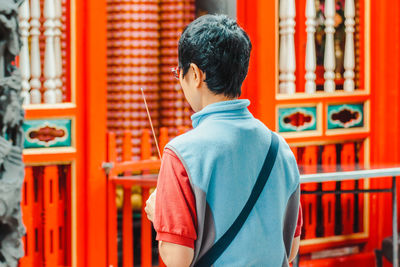 Rear view of man standing at temple outside building