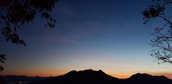 Low angle view of silhouette mountains against sky at sunset