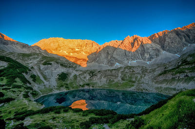 Scenic view of mountains against clear blue sky
